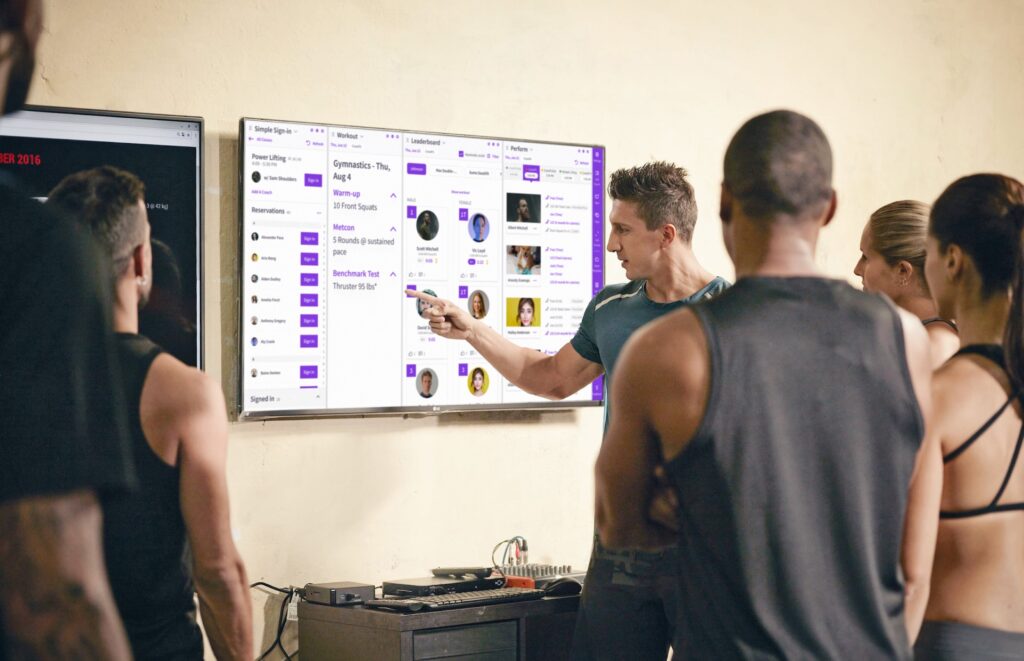 Best PushPress gym software alternative is Wodify as the instructor shows workouts on a board.